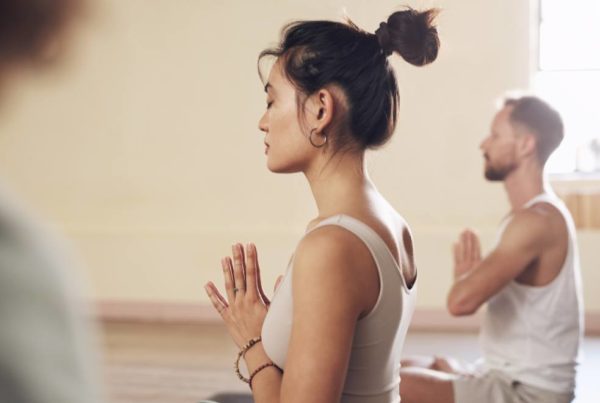 People sitting crossed legged in a yoga studio
